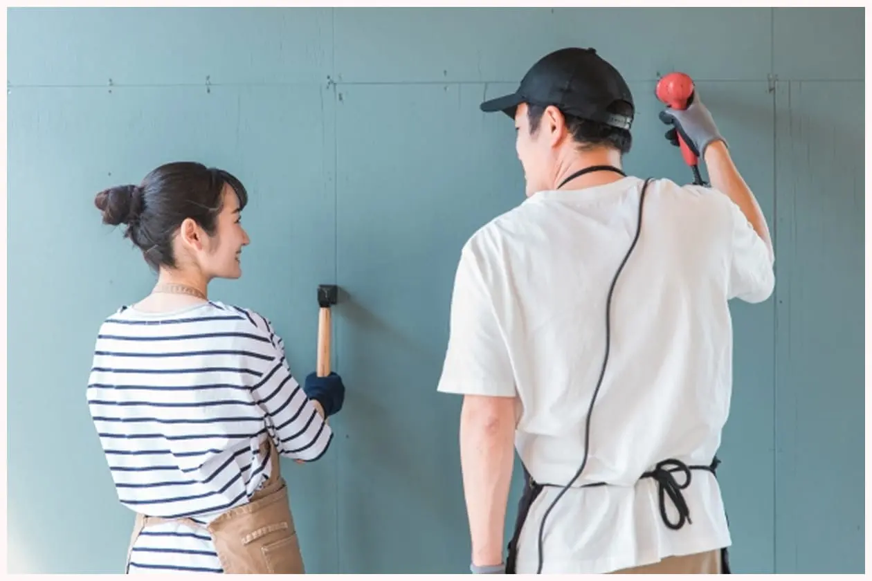 壁に塗装を施す男女のDIY作業風景